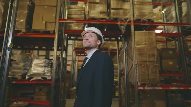 Warehouse manager visiting large warehouse checking distribution.