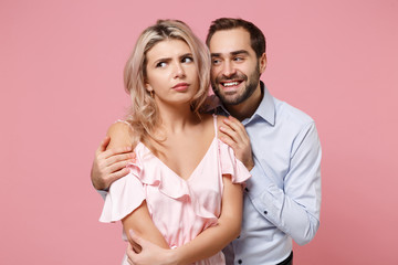 Confused young couple two guy girl in party outfit celebrating posing isolated on pastel pink wall background. People lifestyle Valentine's Day Women's Day birthday holiday party concept. Hugging.