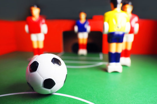 Table soccer, foosball. Soccer ball in the foreground. Sport team football players. Leisure and entertainment