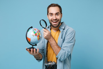 Excited traveler tourist man in yellow clothes with photo camera isolated on blue background....