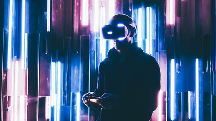 Men in VR headset standing in dark space with neon lights