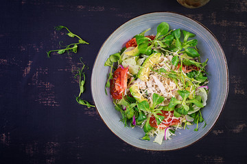 Fresh salad with chicken breast, corn salad, cucumber, avocado and tomato. Chicken salad. Italian cuisine. Healthy food concept. Top view, overhead