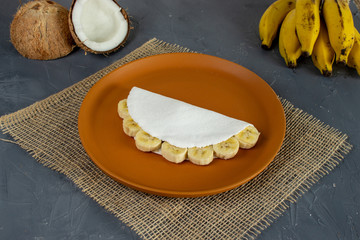 Banana Tapioca, a tradicional Brazilian food. Made from starch of cassava. With banana e casavas in the back.  Close up