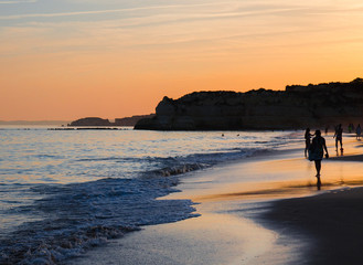 Portugal, Algarve, The best beaches of Portimao, Praia da Rocha, sunset over The Atlantic Ocean, people on the coast of evening Atlantic ocean, the most beautiful beaches of Portugal