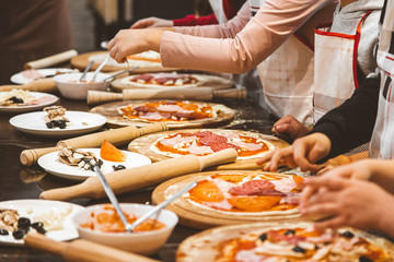 Children cook pizza. Master class from the chef in a restaurant, Close-up of children's hands roll out the dough