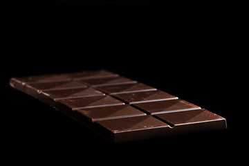 Chocolate Whole Bar on Black Background. Closeup View
