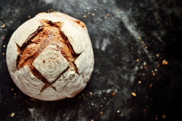 Bakery products. Crispy, beautiful bread on a dark background. Buckwheat, without yeast, wheat bread with flax and sunflower seeds. Top view, place for text.