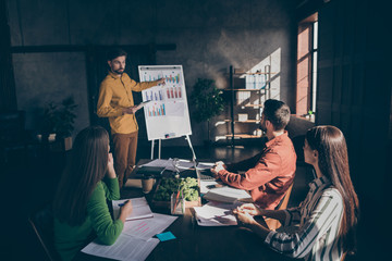 Photo of serious business people having seminar at modern technologies of being entrepreneurs with man standing near charts showing them income increased