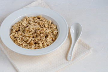 Breakfast consisting of oatmeal porridge. Healthy food, on a light gray background.