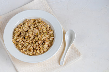 Breakfast consisting of oatmeal porridge. Healthy food, on a light gray background.