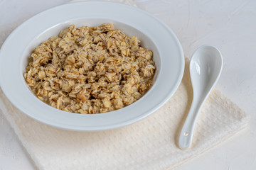Breakfast consisting of oatmeal porridge. Healthy food, on a light gray background.
