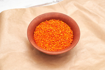 lentil grains in a cup on a paper brown background.
