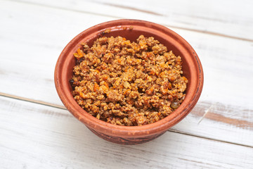 Grilled minced meat in a plate on a light wooden background.