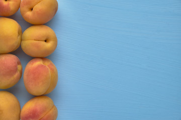 Delicious fresh apricots on a blue background, organic fruits.