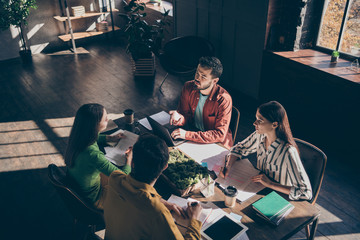 Four busy experienced businesspeople wearing casual formal-wear discussing delegation company growth income at modern industrial loft wooden interior workplace workstation - obrazy, fototapety, plakaty