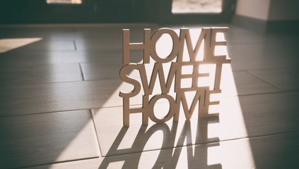 Phrase Home, sweet home made of wood on the background of new house