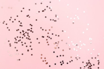Stars confetti scattered on pink pastel background. Monochromatic concept.