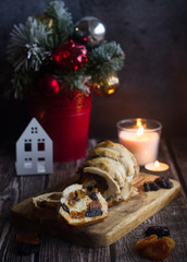 Obraz na płótnie Canvas Tasty turkey roll with prunes and dried apricots on the table. Candles and christmas tree in the background