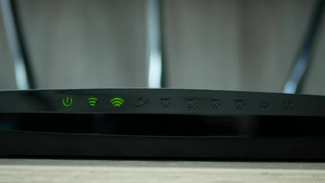 Close-up view of the LED lights blinking on wifi router, it connecting to the internet.