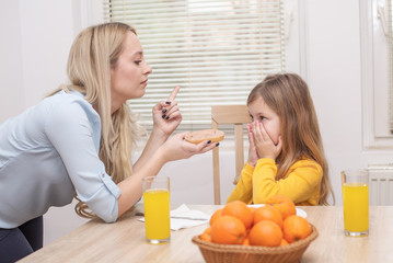 Mom is talking to her daughter who is refusing to eat