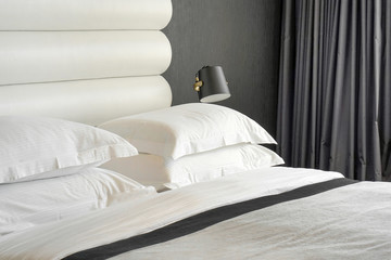 Luxury style bedding with puffy pillow in bedroom. Interior of a hotel bedroom. Modern bedroom interior in the hotel.