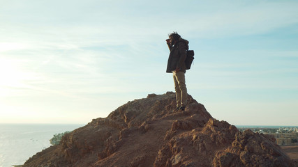 handsome middle eastern male with dreadlocks looking ahead at sunrise