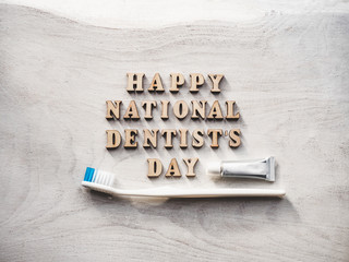 Dentist's day greeting card. White, isolated background, close-up, view from above, wooden surface. Congratulations for relatives, friends and colleagues