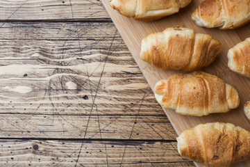 Croissants with chocolate filling on wooden background. Copy space.