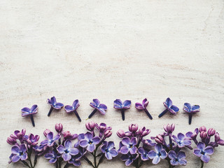 Beautiful, bright lilac lying on a white, wooden table. View from above, close-up