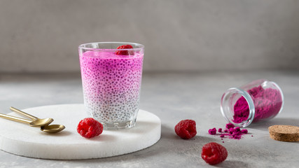 Healthy vanilla chia pudding with pink matcha or spirulina in a glass with fresh berries. Side view. Superfoods, healthy nutrition, dieting