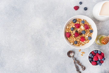 Healthy breakfast. Fresh granola, muesli with yogurt and berries on grey background. Copy space