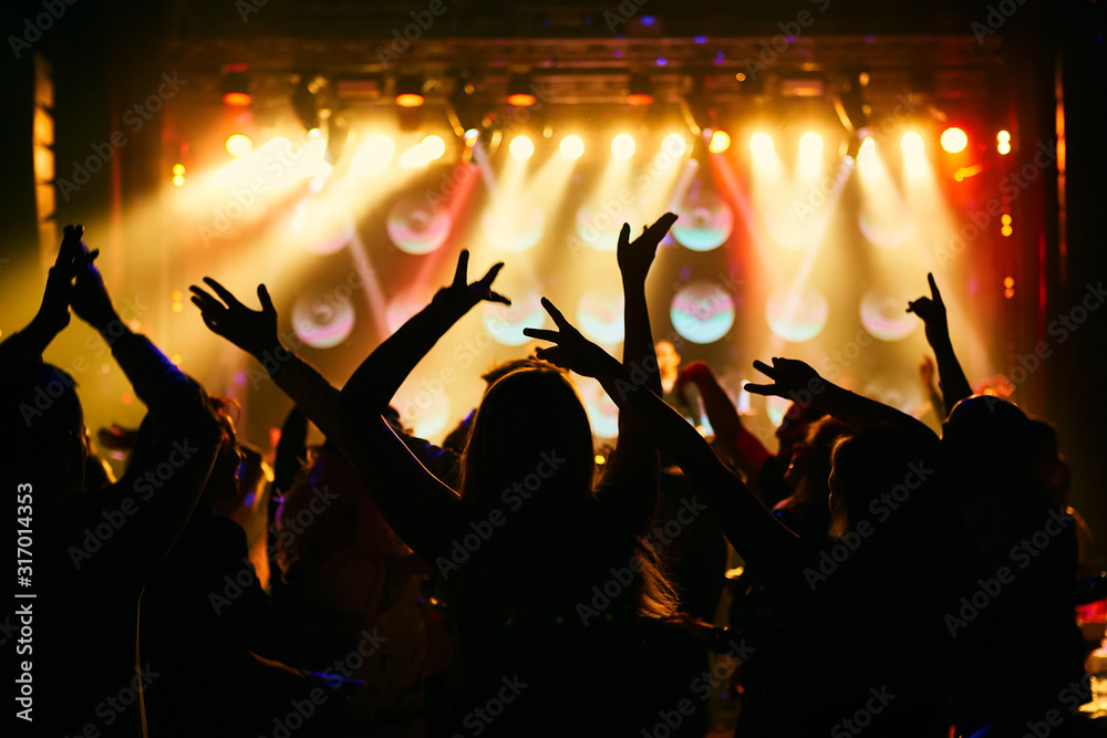 Wall mural silhouettes of concert crowd in front of bright stage lights