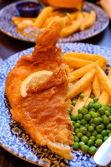 Traditional British food fish and chips served with green peas