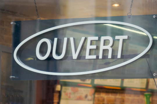 Open Sign In French Means Ouvert Hanging On The Entrance Door Of A Small Business Concept In France