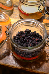 Tastes of gin, botanicals ingredients for gin distillery process, pot with dried mulberries