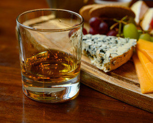 Tasting of original scottish cheese and whisky, plate with scottish cheeses and variety of Scotch in glasses