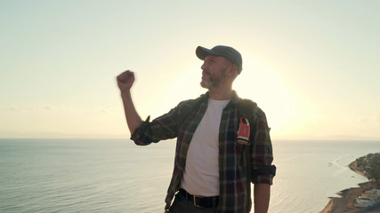 Handsome senior traveler shake his hand in success gesture