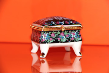 Ceramic jewelry box on an orange background