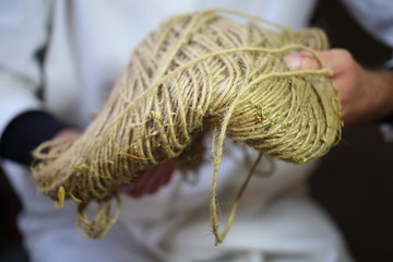 Scientist pours hemp seeds from a beaker into an iron tank