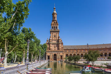 Fototapeta na wymiar Rowing boats in front of the tower at Plaza Espana in Sevilla, Spain
