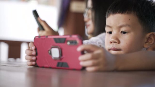 Asian boy about 3 years and 10 months addiction and keep using mobile phone for watching cartoon application