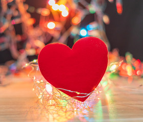 A red heart surrounded by lights bokeh on black background,