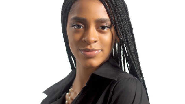 portrait of mixed race black woman with hair braids watching to the camera directly. Ideal skin neutral makeup
