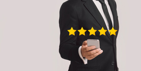 Unrecognizable Businessman Evaluating Mobile App On Cellphone With 5 Stars