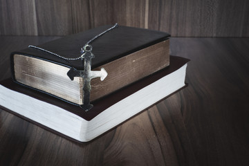 The crucifix lay on the bible. It is a blessing from God with the power and power of holiness, which brings luck and shows forgiveness with the power of religion, faith, worship, Christian thought.