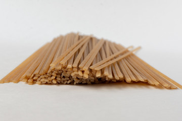 Long flat brown macaroni on a white background.