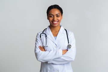 Portraif of black female doctor with stethoscope posing with crossed hands