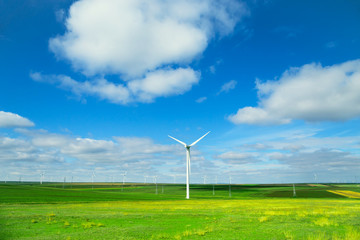 Fototapeta na wymiar Wind turbines against beautiful blue sky with clouds. Eolic park.