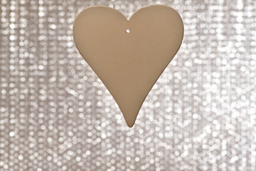 Heart. One  white wooden heart with a hole for the ribbon on a shiny gray background on the center.  Valentine's day, February 14.