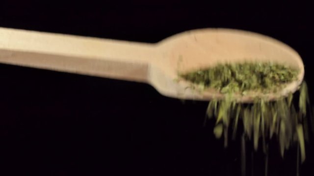 One spoon of dried lovage. Spices and food ingredients.